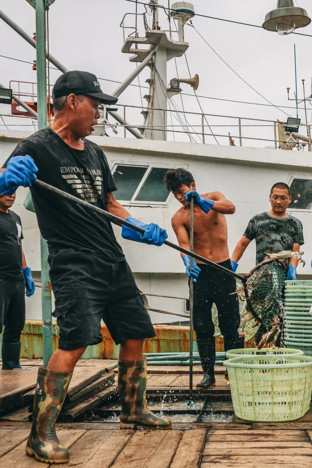 渔船上劳作的渔民。摄影/吴学文