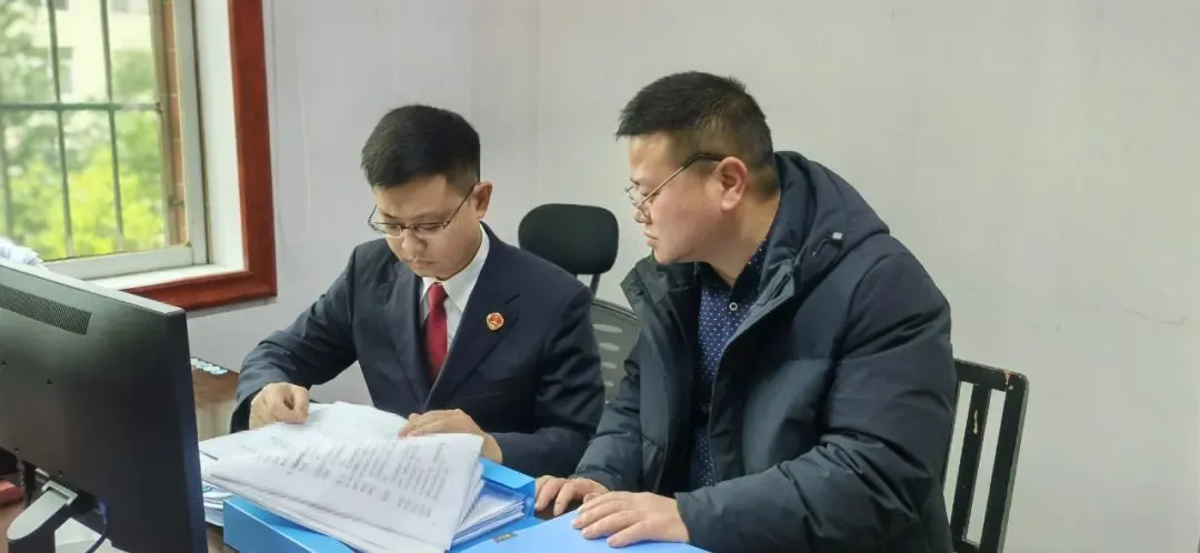 承办检察官在洪江市医保局查阅医保基金记账凭证等情况。