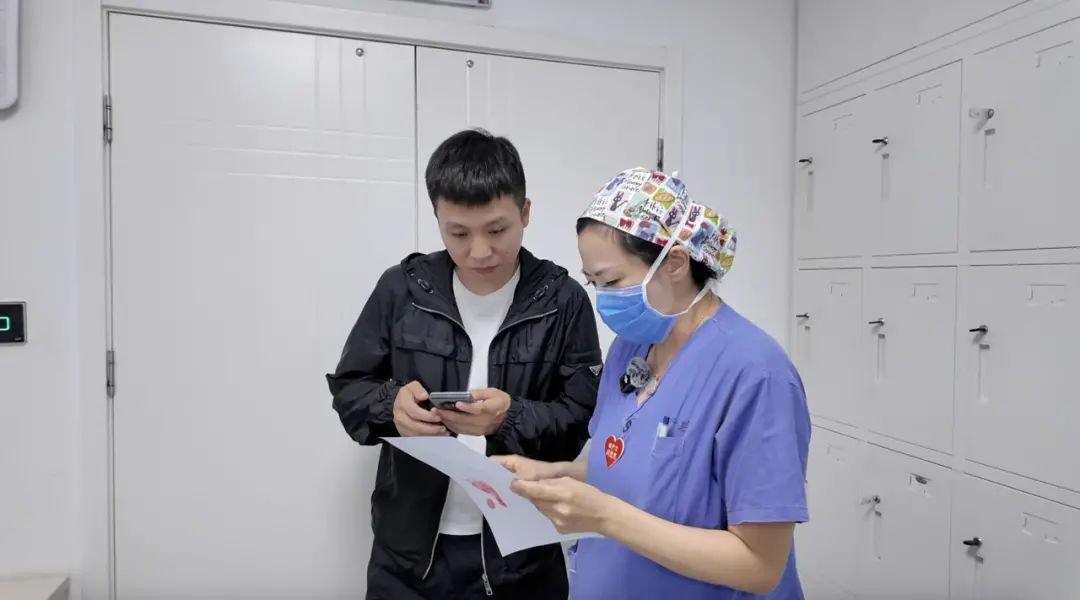 葛迪在手机上记下新生儿出生信息/记者拍摄