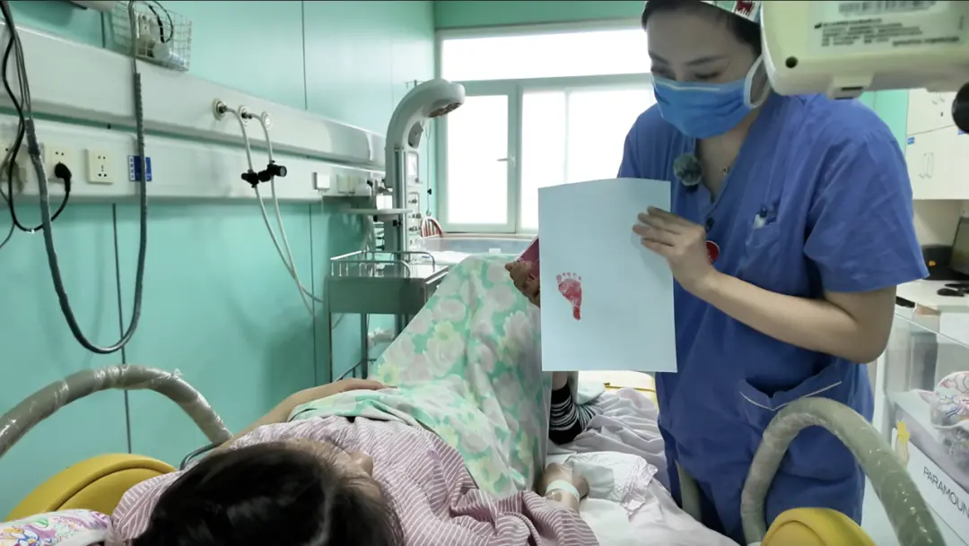 产妇看向新生儿脚印/记者拍摄