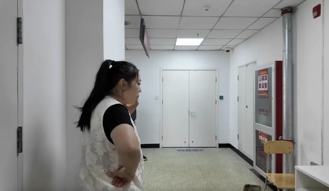 产房外的赵丽丽和家人打电话/记者拍摄