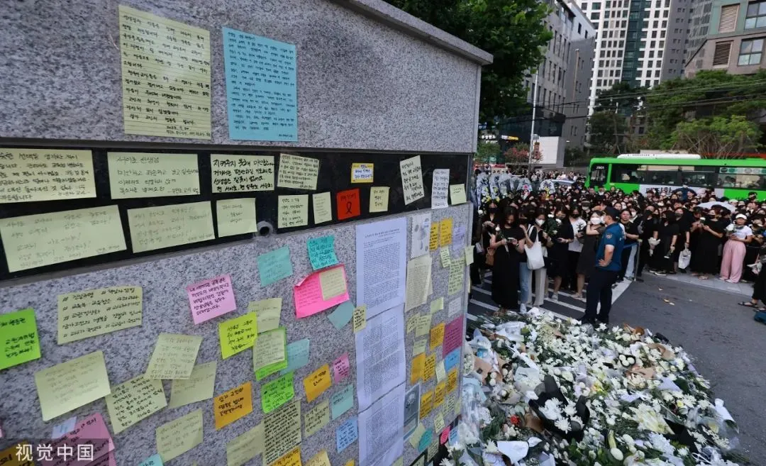 当地时间2023年7月20日，韩国首尔，江南区瑞西小学前门摆满了吊唁信息和鲜花，哀悼18日自杀身亡的女教师的人们排起了长队