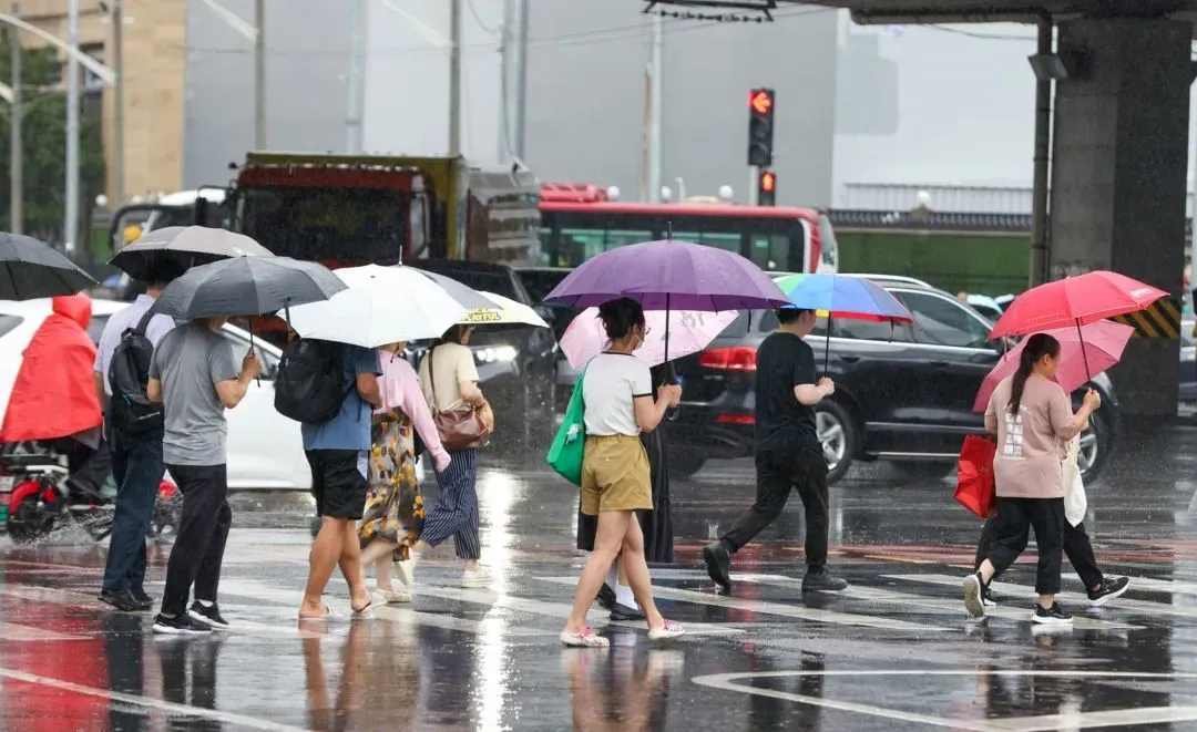 北京早高峰，市民冒雨出行