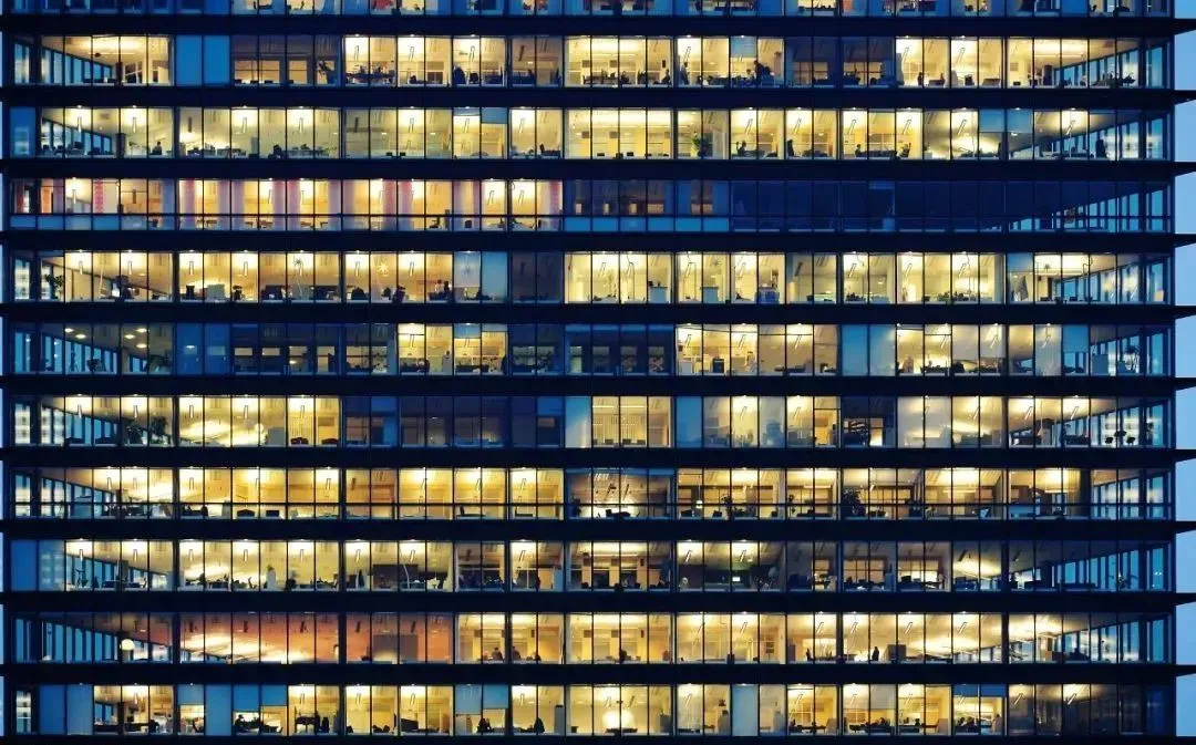 灯火通明的办公室大楼 图源：“央视网”微信公众号