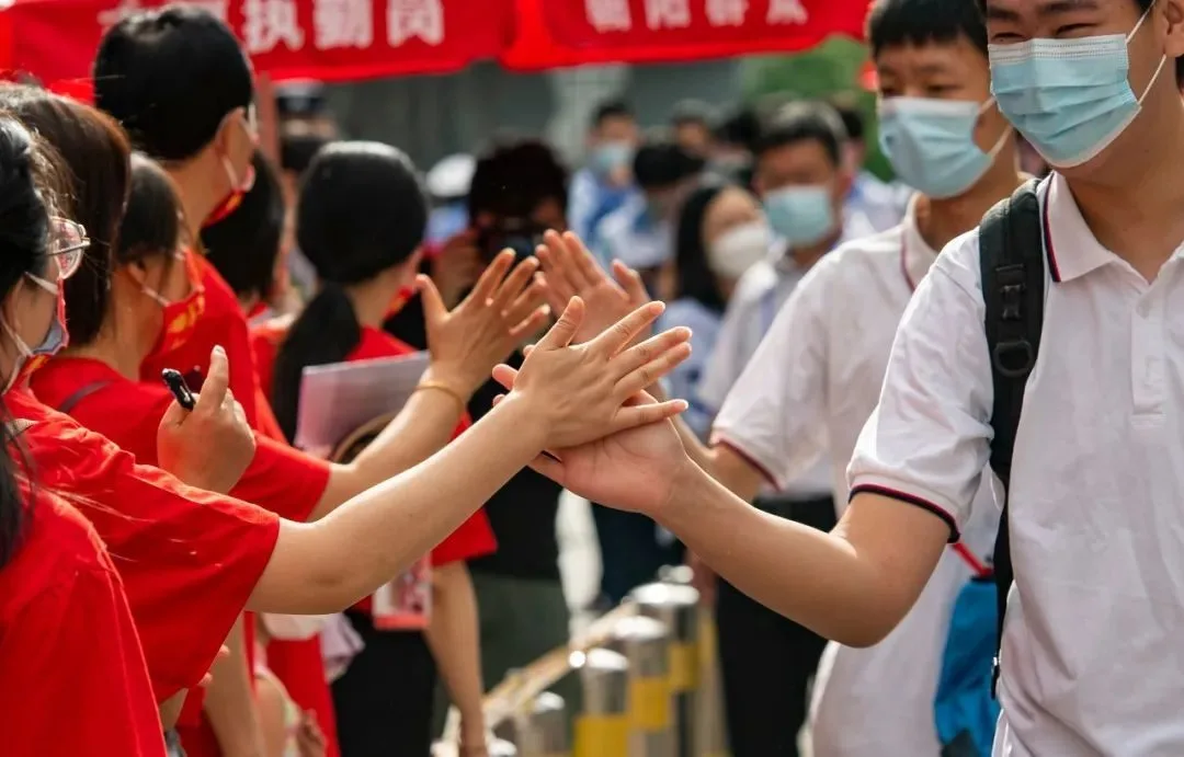 6月7日上午，北京市朝阳区陈经纶中学考点外，参加高考的学生入场前与送考老师击掌。当日，2022年全国高考拉开帷幕。中新社记者 侯宇 摄