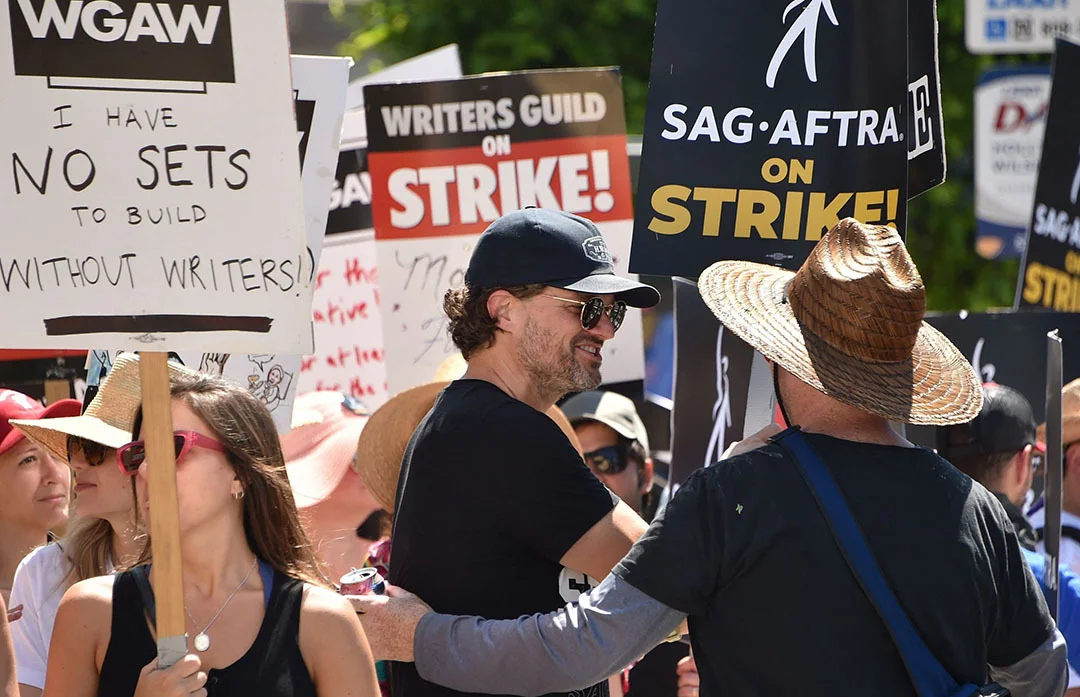 当地时间2023年7月18日，美国加州洛杉矶，美国演员马特·琼斯与美国编剧协会和演员工会的成员走在罢工的队伍中。