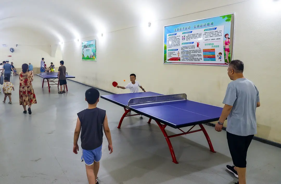 △武汉市民在蛇山人防工程纳凉点内打乒乓球。（图/视觉中国/中新社记者张畅）