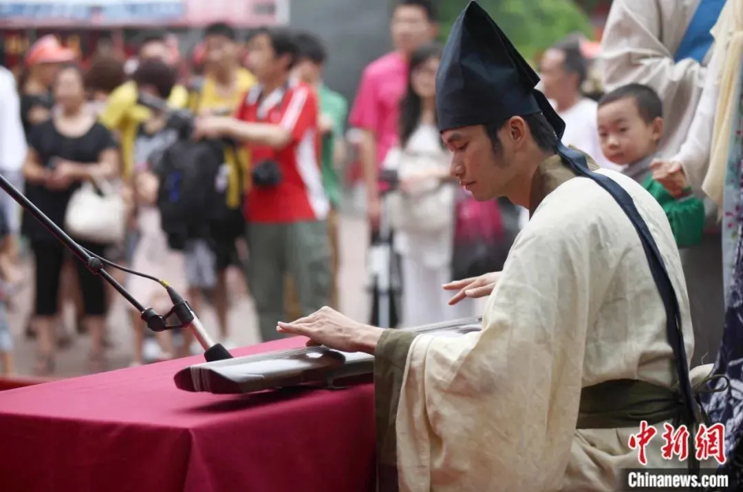 在一场青岛市民俗博物馆举行的端午民俗活动中，身穿传统汉服的演职人员弹古琴，并吟诵《楚辞》。徐崇德 摄