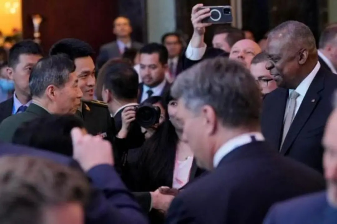 美国国防部长奥斯汀（右）在香格里拉对话会宴会期间主动找中国国防部长李尚福（左）握手