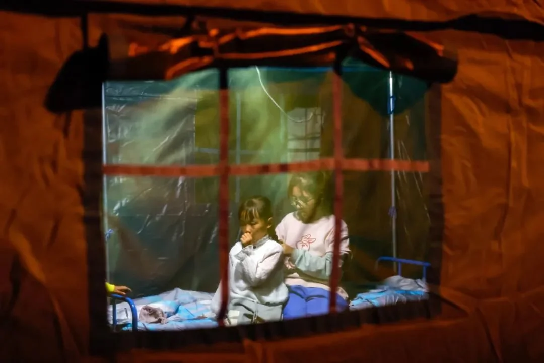 9月5日晚，在四川甘孜州泸定县磨西镇受灾群众临时安置点，两名小女孩在帐篷里（新华社记者 沈伯韩 摄）