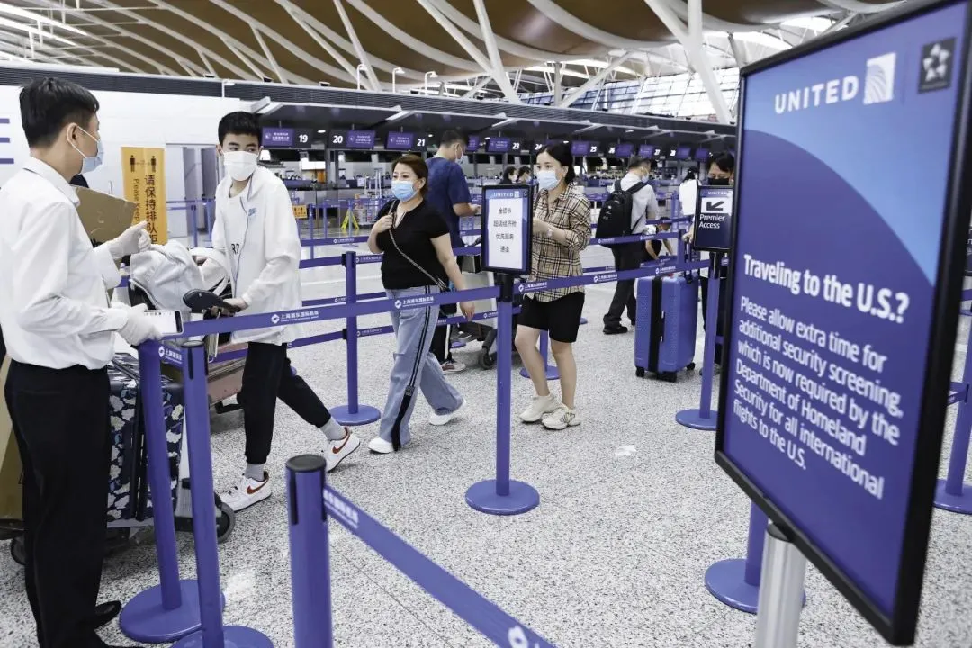 2021年8月19日，上海，留学生与家长在浦东机场T2航站楼内有序排队，等待办理登机手续。（@视觉中国 图）