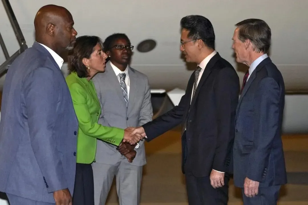8月27日，美国商务部长吉娜·雷蒙多（左二）抵达北京首都国际机场，与中国商务部美大司司长林峰和美国驻华大使尼古拉斯·伯恩斯（右）握手。雷蒙多将访问北京和上海。