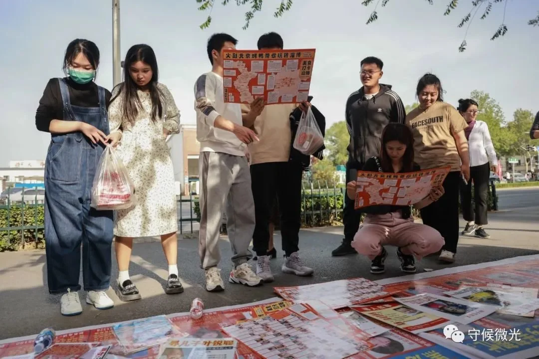 5月1日，山东淄博，一些年轻人停下脚步，关注和记录寻亲信息。中青报·中青网记者 曲俊燕/摄