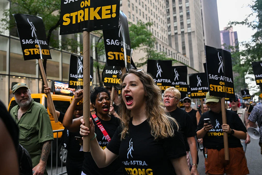 当地时间2023年7月14日，美国纽约，美国编剧协会和美国演员工会的成员走在罢工的队伍中。本文图片均为 视觉中国 图