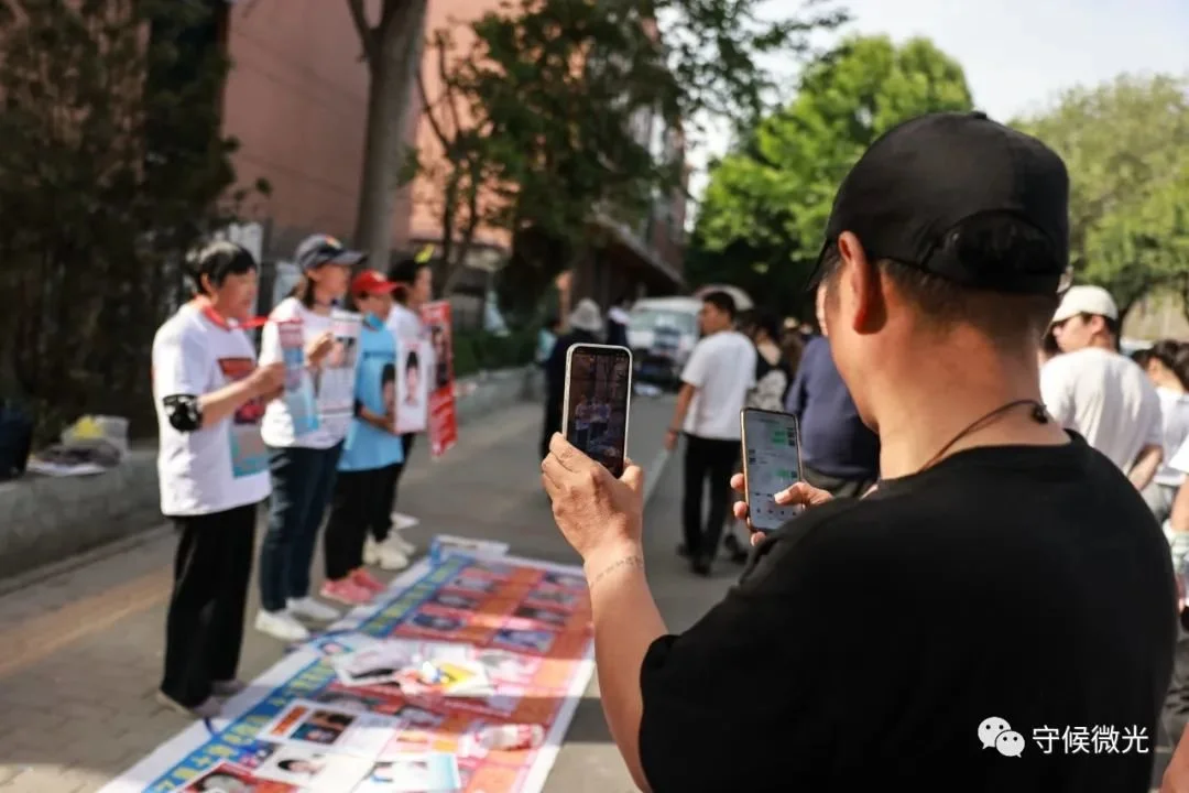5月1日，山东淄博，一名游人拿出手机直播寻亲现场。中青报·中青网记者 曲俊燕/摄