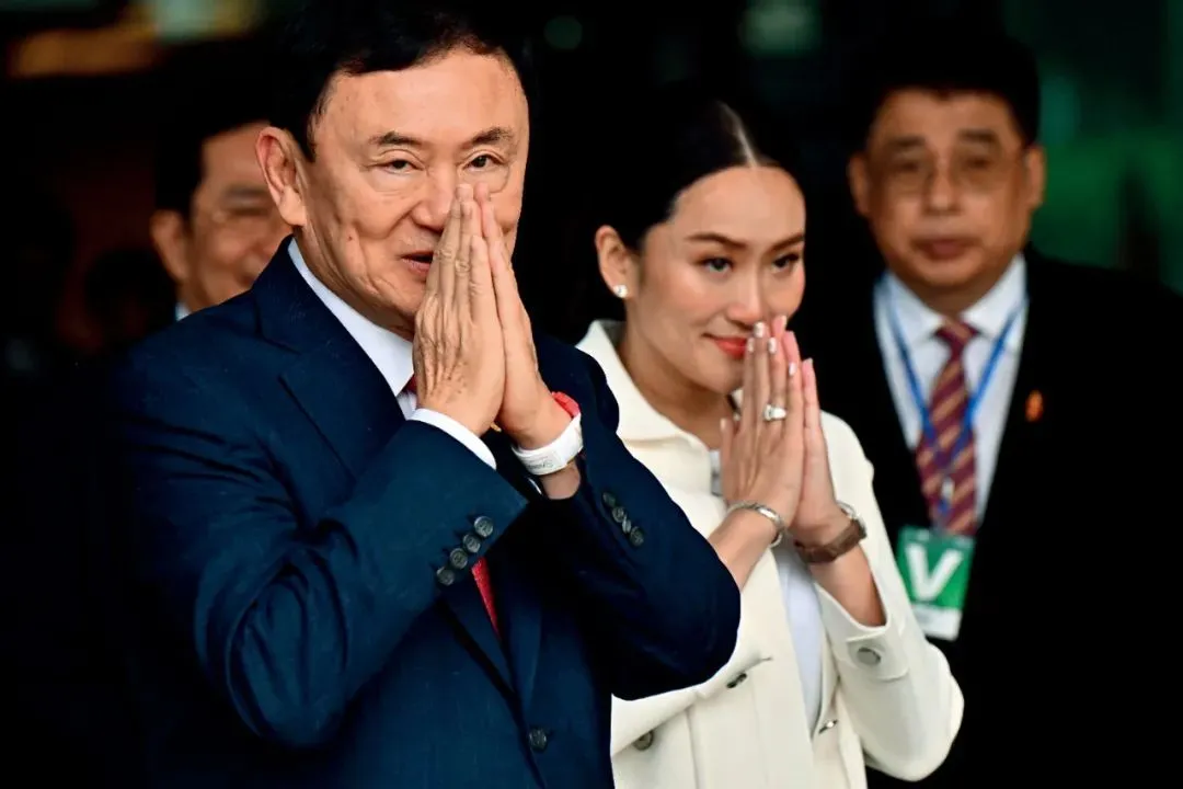 8月22日，泰国前总理他信抵达曼谷廊曼国际机场后，与小女儿贝东丹一起向支持者致意。