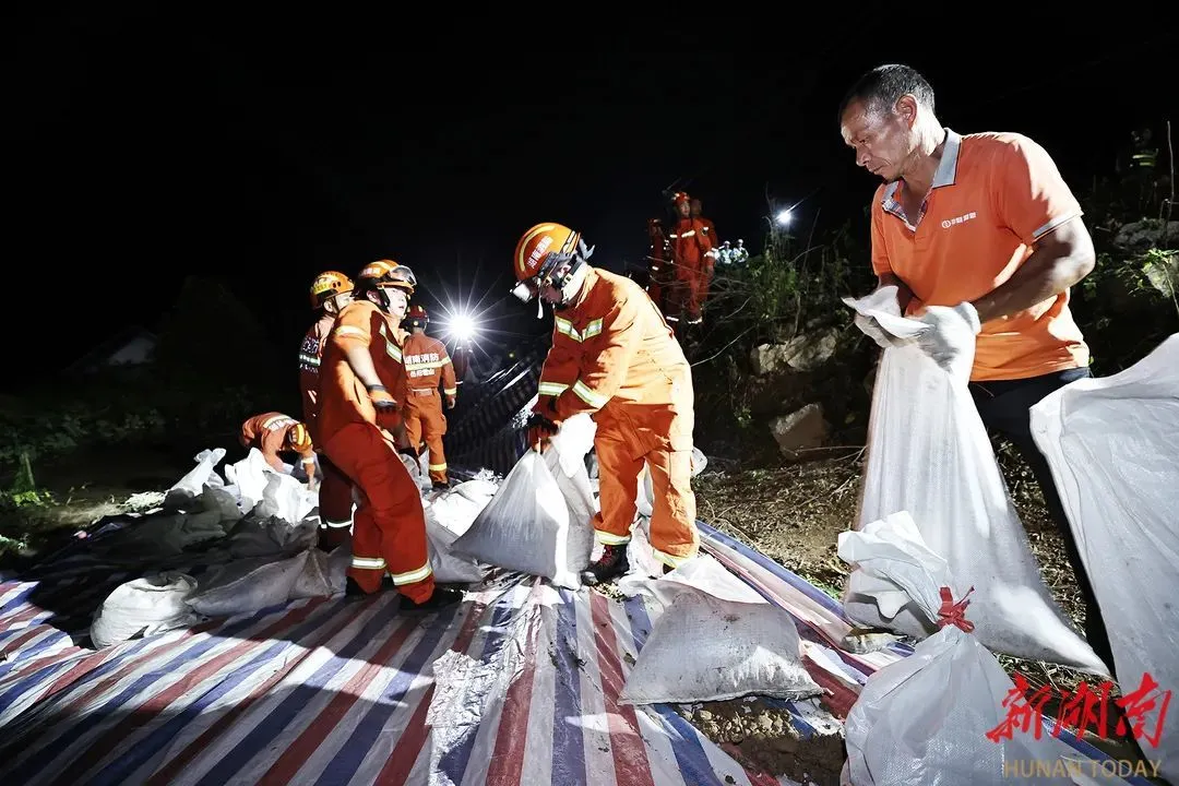 （7月6日凌晨，抢险救援人员在华容县团洲垸洞庭湖堤防决口附近抢筑间堤。）