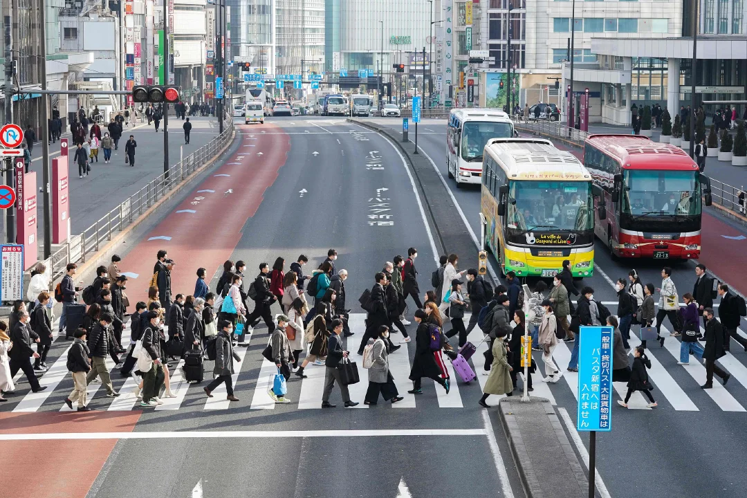 当地时间2024年2月15日，日本东京，早晨通勤上班的人们穿过人行横道。本文图片均为视觉中国 图