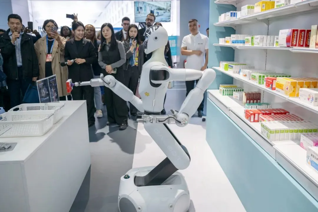 10月14日，全球妇女峰会参会嘉宾在北京经开区机器人大世界参观。图为嘉宾观看机器人演示拿取药品 图源：新华社