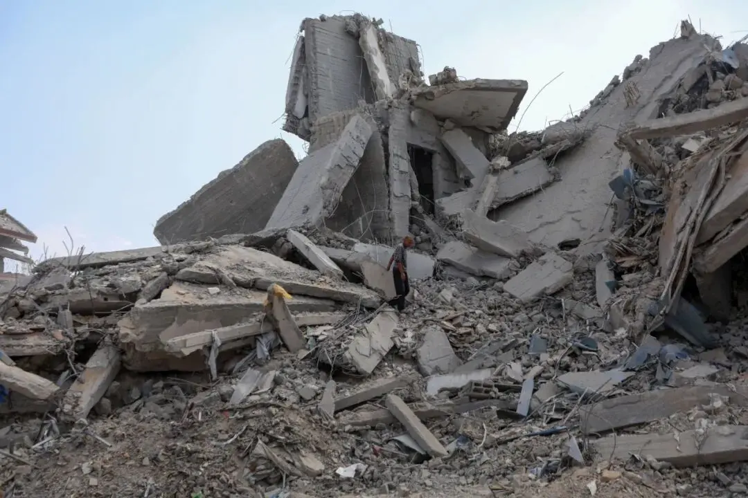 10月29日,一名巴勒斯坦人在加沙城查看遭以色列军队空袭后的废墟——以色列军方当日宣布恢复执行停火协议后,又于当天傍晚空袭加沙地带北部一处目标 图:新华社