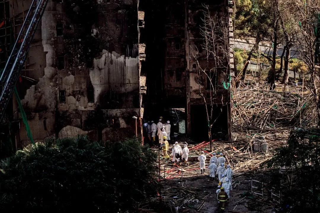 上图：11月26日下午，宏福苑火灾现场，71岁的王先生哭喊妻子被困火场。图/IC