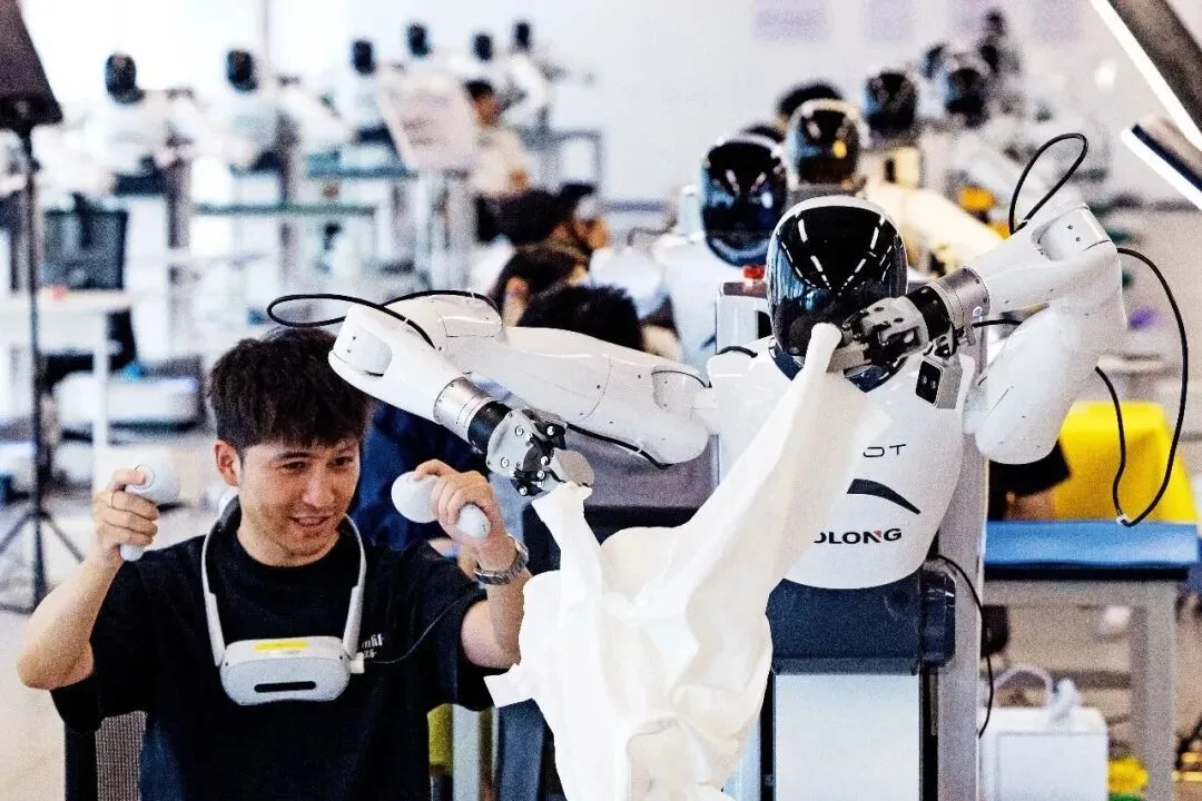 2025年9月,在位于浙江绍兴的杭州湾具身智能创新中心,工作人员操作机器人进行不同场景作业的数据采集。图/视觉中国