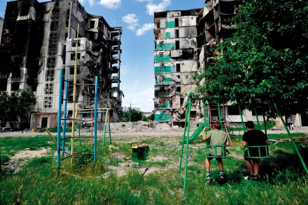 6月7日，乌克兰基辅州博罗江卡镇，两个男孩在一处住宅楼前荡秋千。图/视觉中国