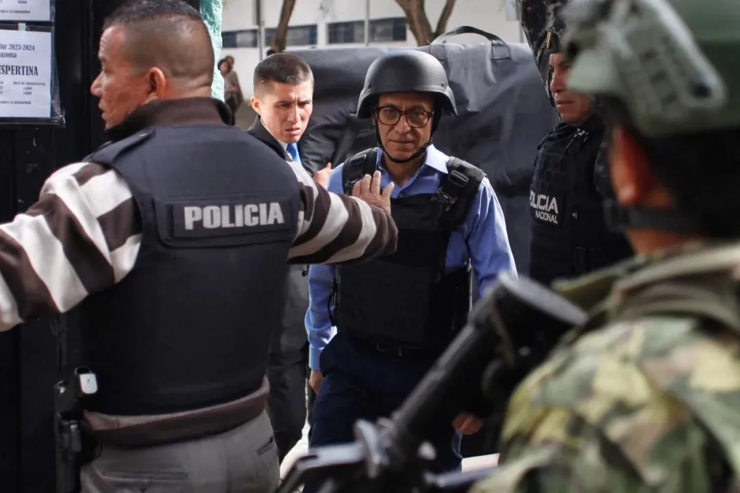 ▲20日，戴着头盔、穿着防弹背心的厄瓜多尔总统候选人克里斯蒂安·苏里塔在严密护卫下抵达投票站。（法新社）