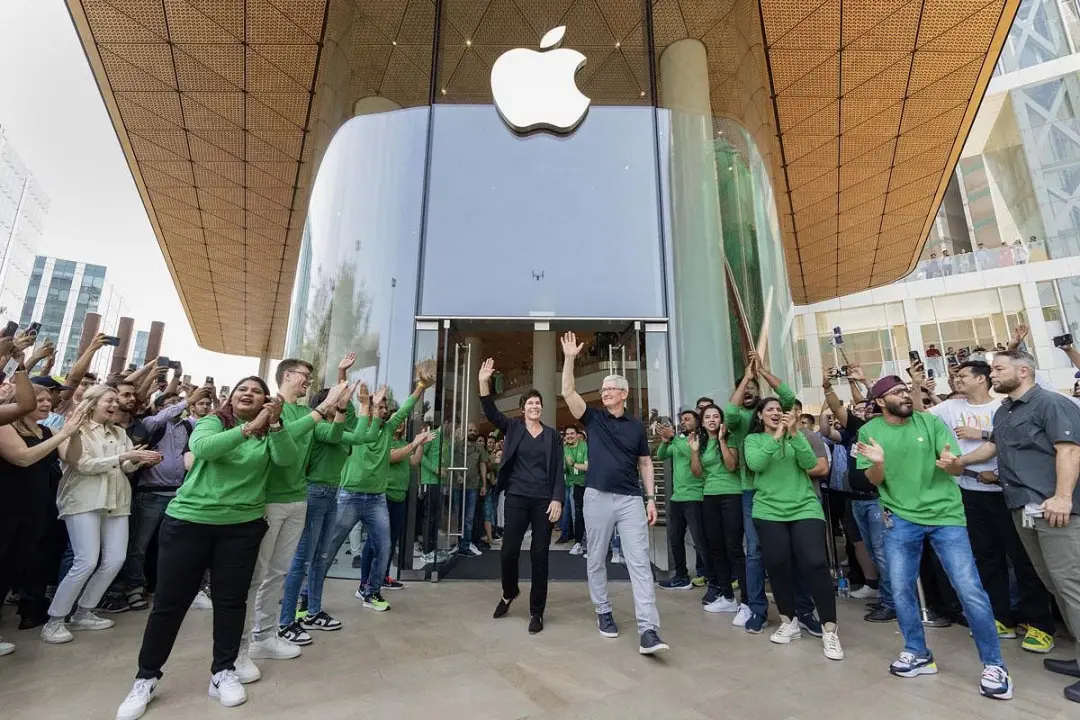 图片内容：苹果在印度的首家直营店开张，苹果CEO库克和用户打招呼