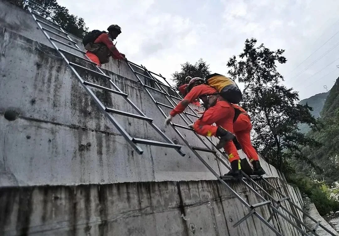 2022年9月5日，四川甘孜，消防救援人员因山体滑坡、道路中断，通过攀爬挺进磨西镇（图源：视觉中国）