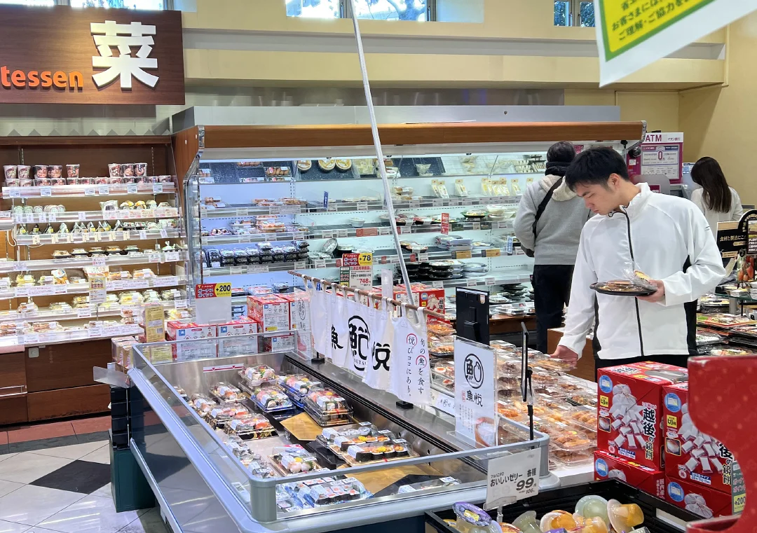 当地时间2023年12月22日，日本东京都港区，市民在超市选购食材。