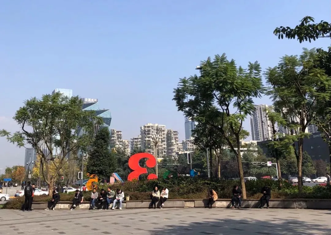 △ 天府三街巨大的“3”雕塑后面小广场，忙里偷闲晒太阳的上班族。图by污姐