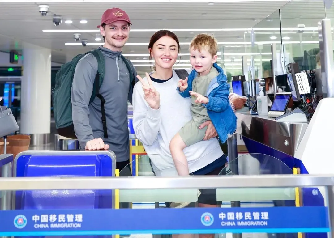 12月18日，在海口美兰边检站，入境旅客在排队等候边检查验期间留影/新华社发（孙浩戎 摄）