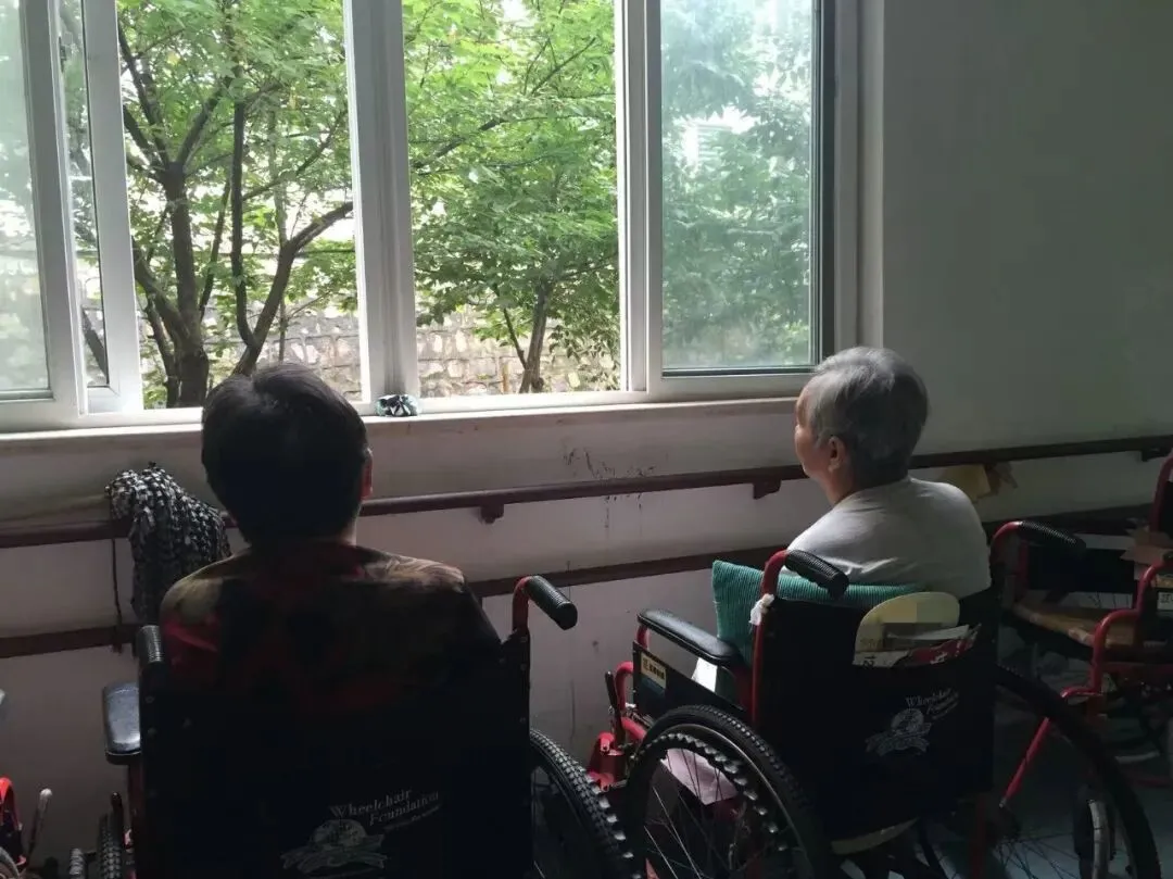 每天上午，护理员打扫房间时会将老人都推到走廊上 ｜ 受访者供图