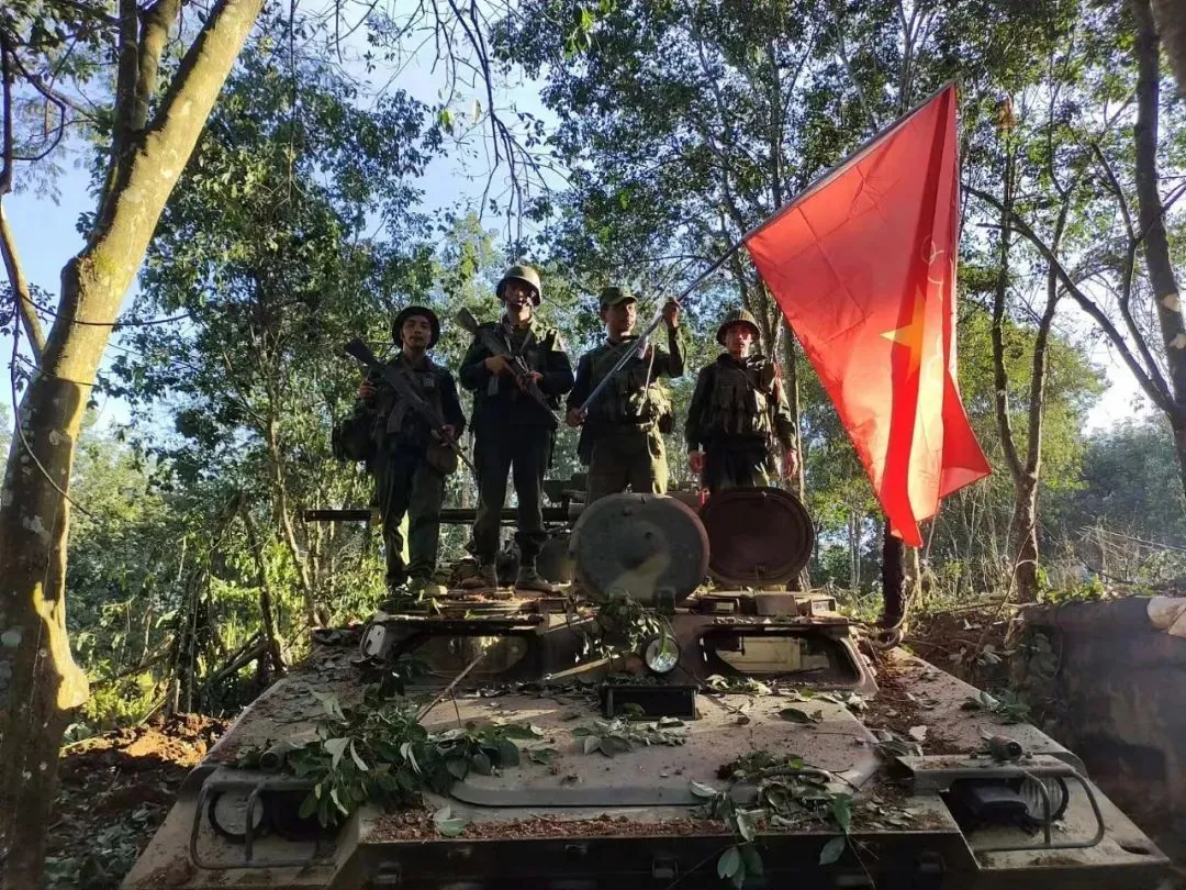 当地时间2023年10月28日，缅甸清水河，缅甸民族民主同盟军的成员在一辆被俘的军队装甲车上举着该组织的旗帜