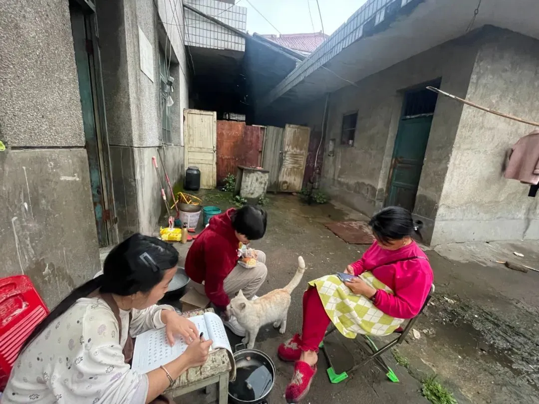 星星母女和夏夏坐在自家门口玩耍