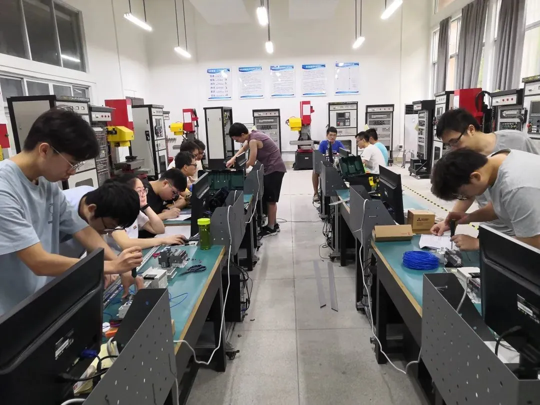 ◎ 郑天晨和同学进行数控机床实训