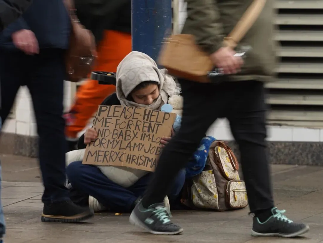 时值岁末，在美国纽约时常可见无家可归者和其他寻求救助的人们。图为12月17日，一名女子在纽约曼哈顿一处地铁站寻求救助 图源：新华社