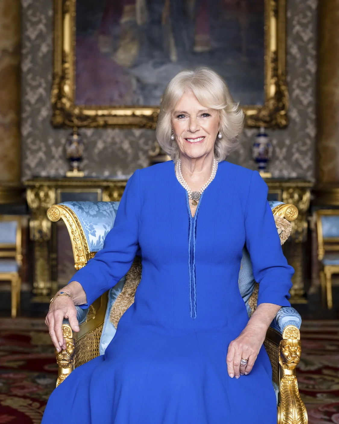 这张由白金汉宫于4月28日公布的照片显示，在白金汉宫的蓝色客厅，卡米拉王后坐在一把1812年的丝绒镀金软垫肘椅上。Hugo Burnand/Buckingham Palace/视觉中国 图