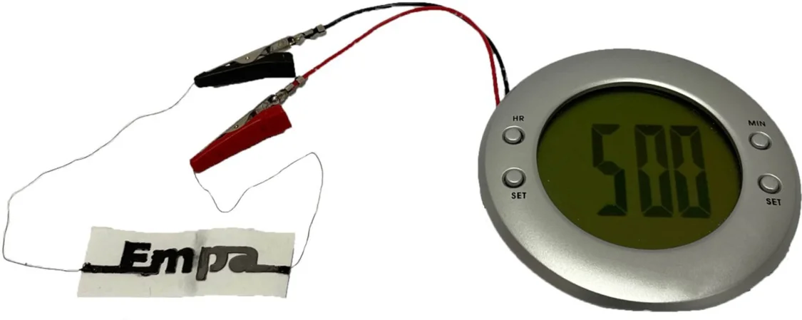 图｜两单元纸电池正在驱动一个有 LED 的闹钟。（来源：研究团队）