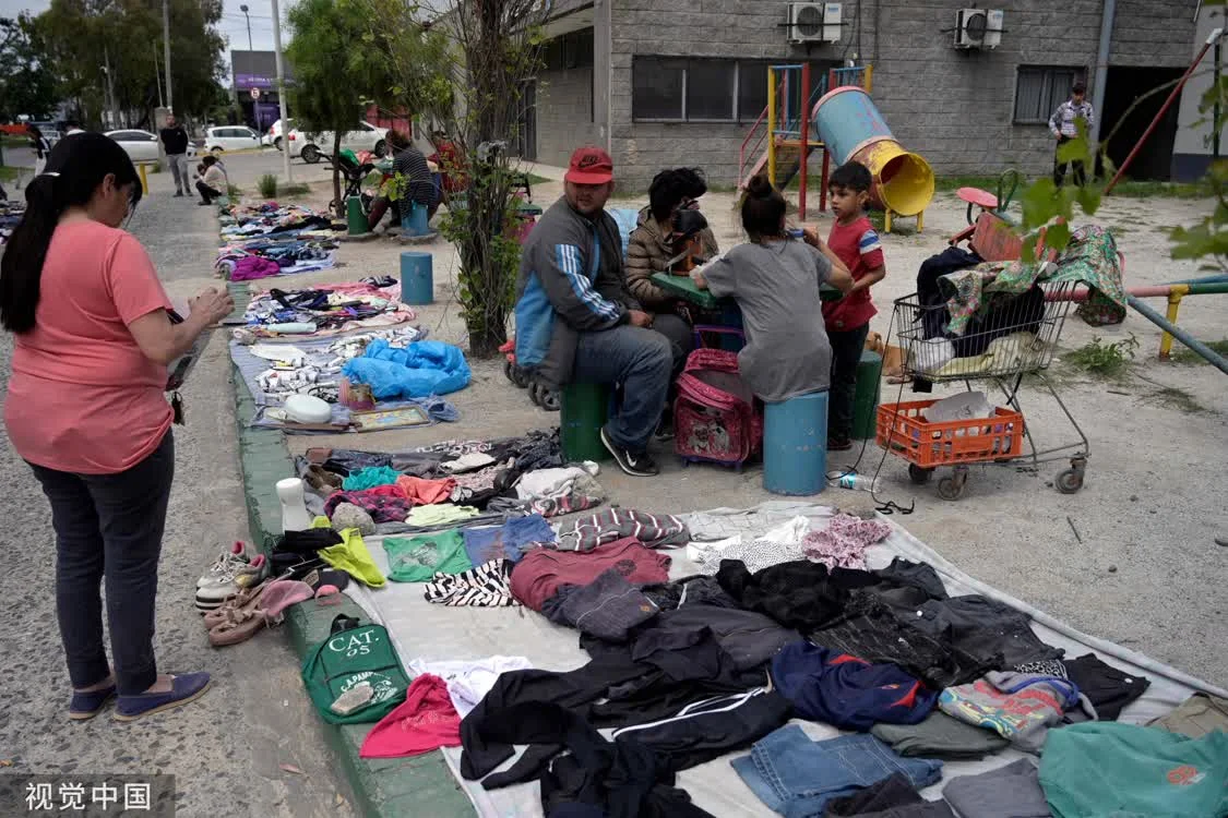 当地时间11月13日，阿根廷布宜诺斯艾利斯省，人行道上陈列着易货或出售的旧衣服。越来越多的阿根廷人依靠以物易物的方式生存。图自视觉中国