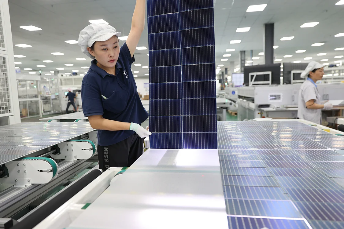2023年8月28日，江苏连云港市赣榆经济开发区一家新能源企业，工人正在加紧生产一批出口海外的太阳能光伏电池组件。 图自IC Photo