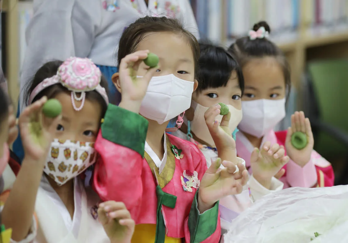 当地时间2022年9月1日，韩国光州，在北区梁山东居民中心，身穿韩服的幼儿园学生们正在制作年糕。 视觉中国 资料图