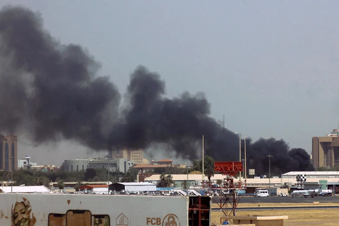 ↑当地时间2023年4月15日，苏丹喀土穆机场附近的建筑物上空发出浓烟。图据视觉中国