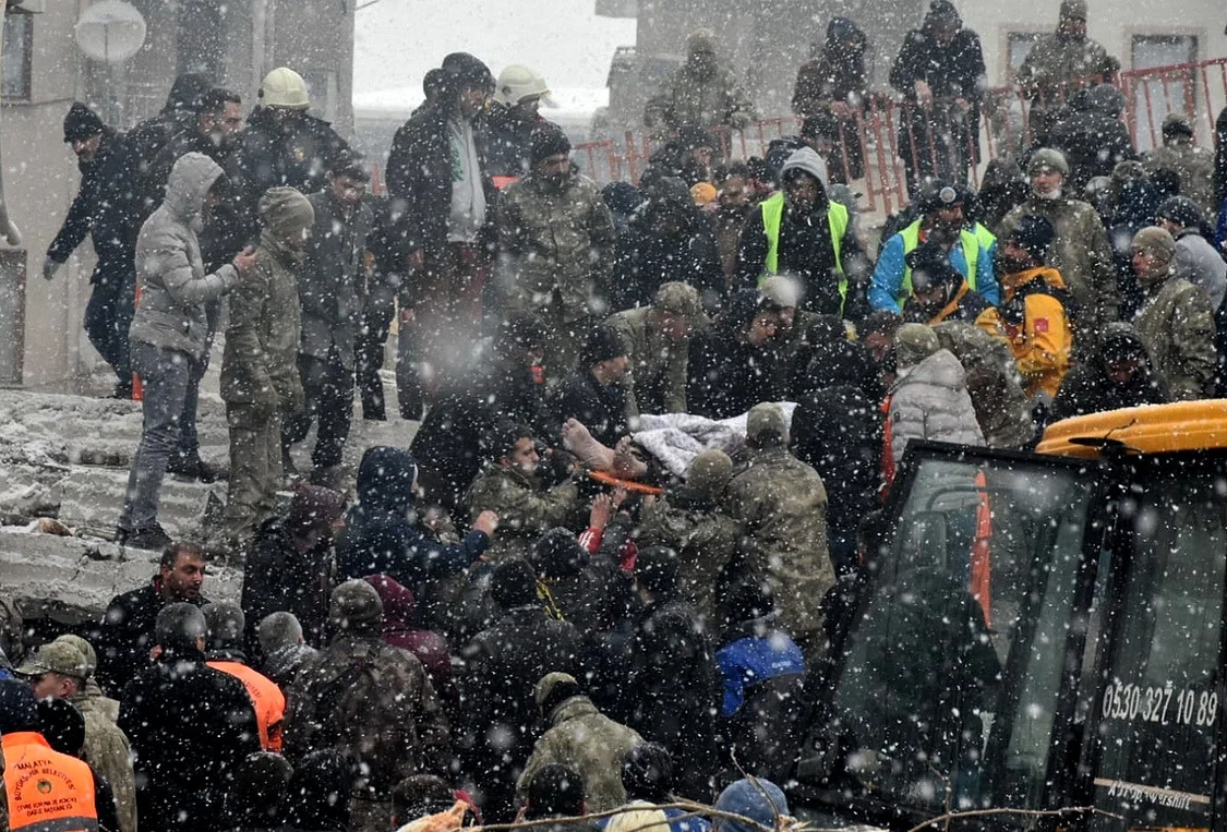 当地时间2月6日，土耳其南部省份马拉蒂亚，漫天大雪给搜救工作带来挑战，一名幸存者从建筑物残骸中被救出。
