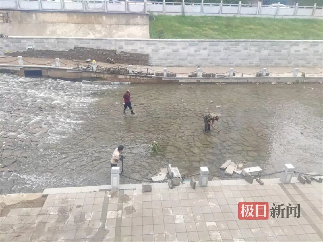 金水河河道一段景观步道出现损坏，工人在河道中寻找瓷砖和护栏