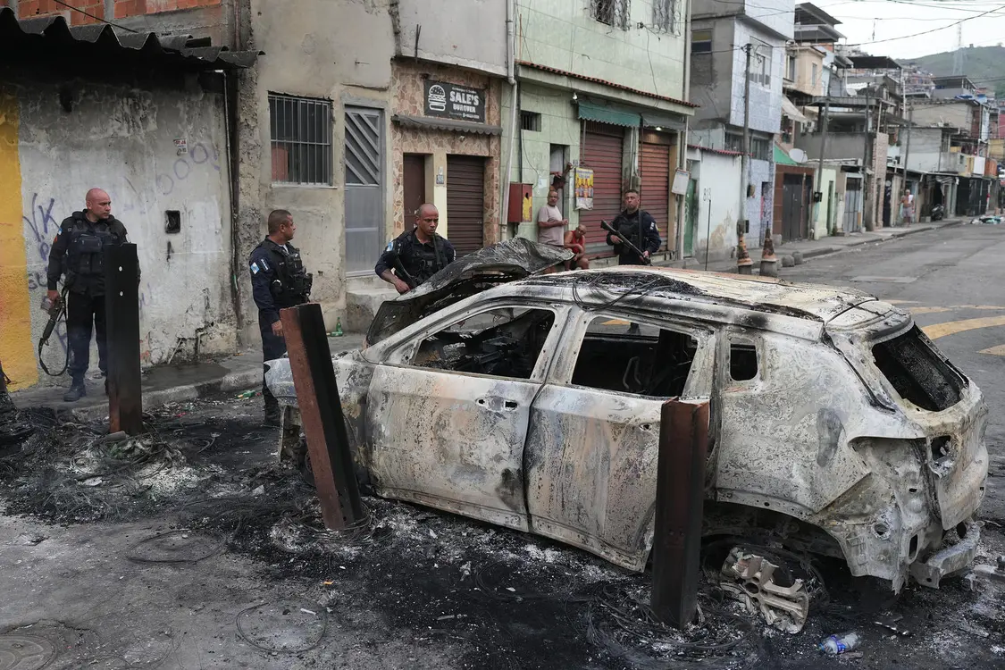 ▲10月28日，里約熱內(nèi)盧警察查看一輛被焚毀的汽車 圖據(jù)視覺中國(guó)