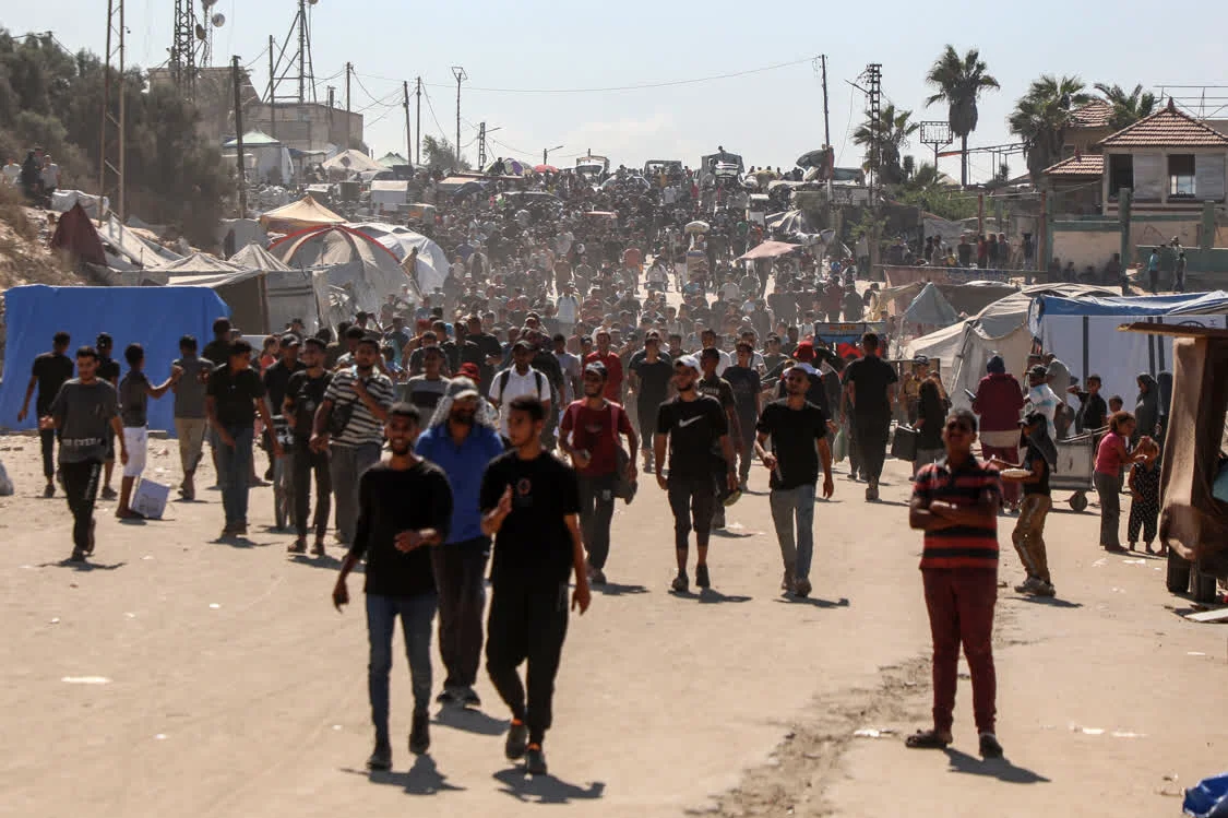 10月10日,在加沙地带中部,大批逃离家园的巴勒斯坦民众走在返回加沙城的路上。新华社发(里泽克·阿卜杜勒贾瓦德摄)