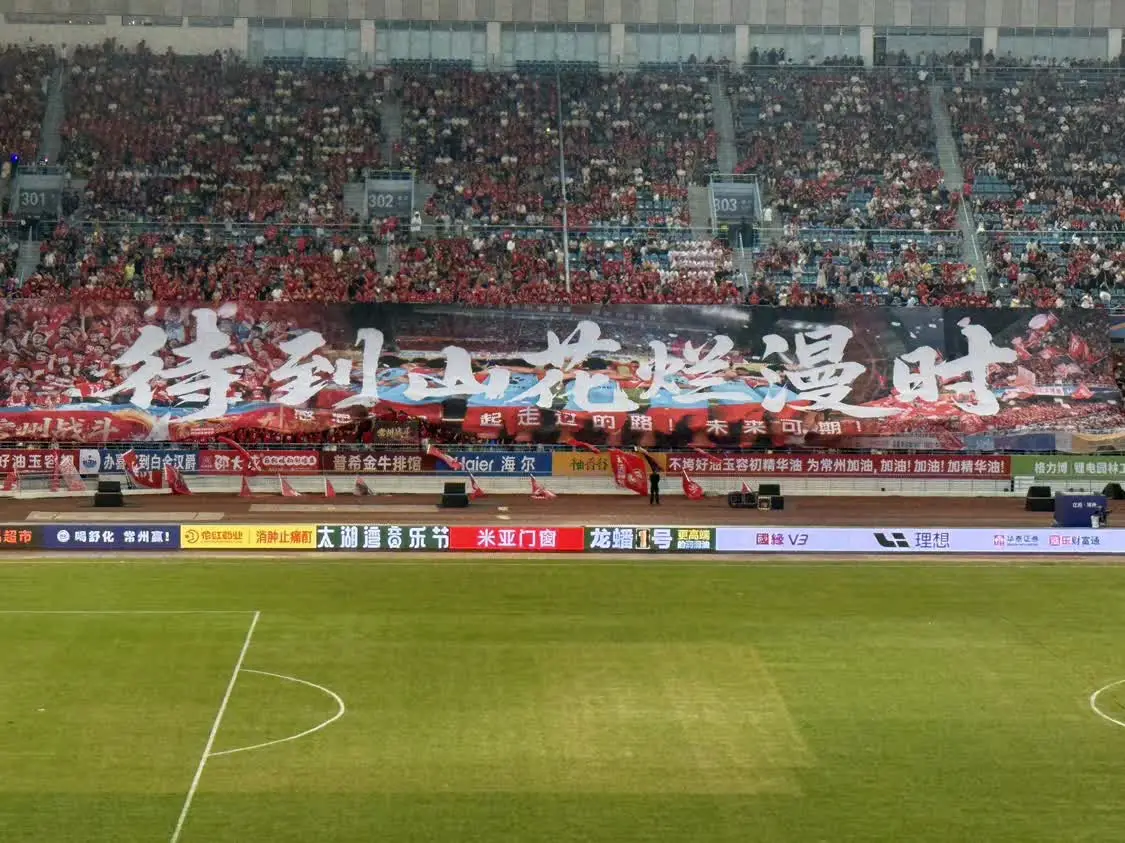 9月13日,球迷助威团方阵在今年苏超常州队最后一个主场,展开巨幅Tifo“待到山花烂漫时。”(图源:常州发布)