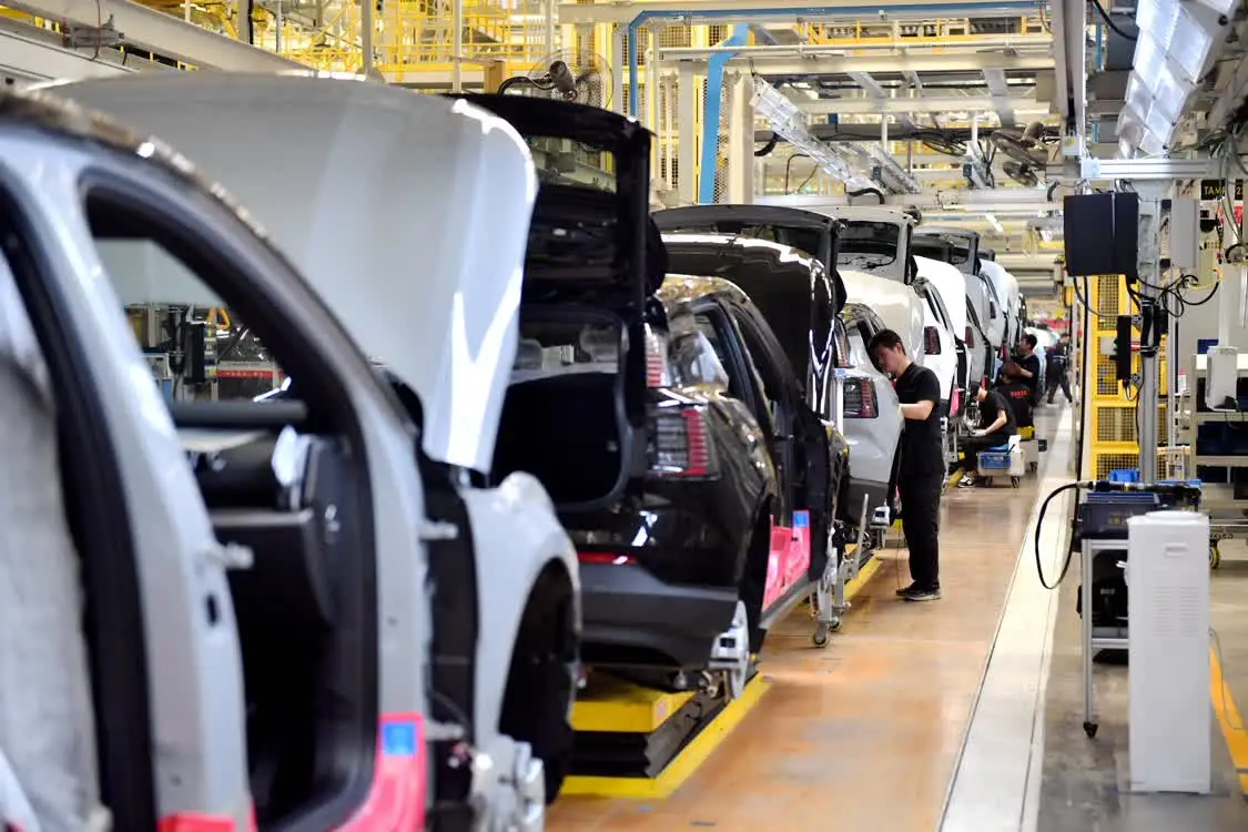 6月19日，工作人员在张家口南山汽车产业基地一家车企的总装车间组装汽车。新华社记者 王晓 摄